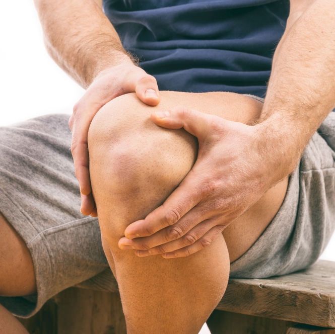 Man holding knee in pain