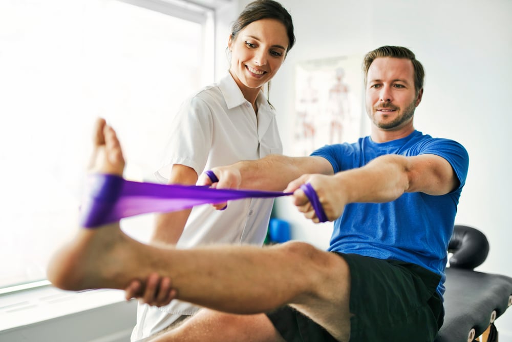 Person stretching leg with exercise band