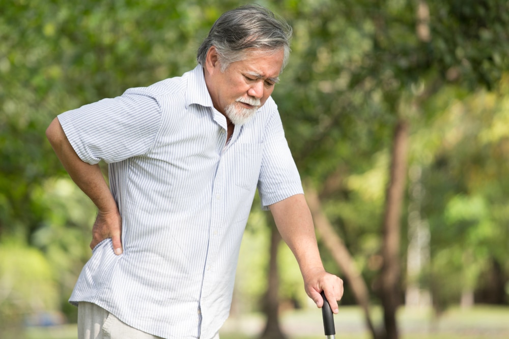 Elderly man with back pain outdoors