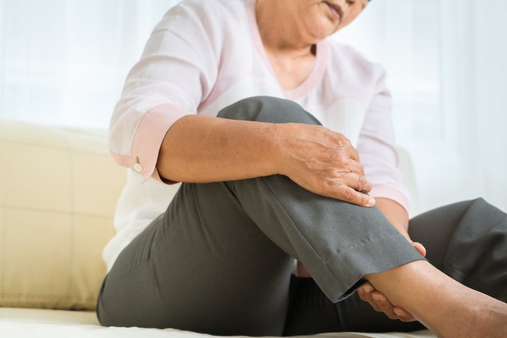 Elderly woman suffering from arthritis in ankle